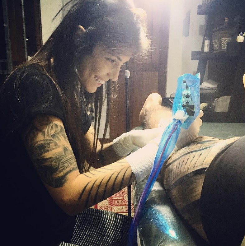 Thais Valente while making tattoos